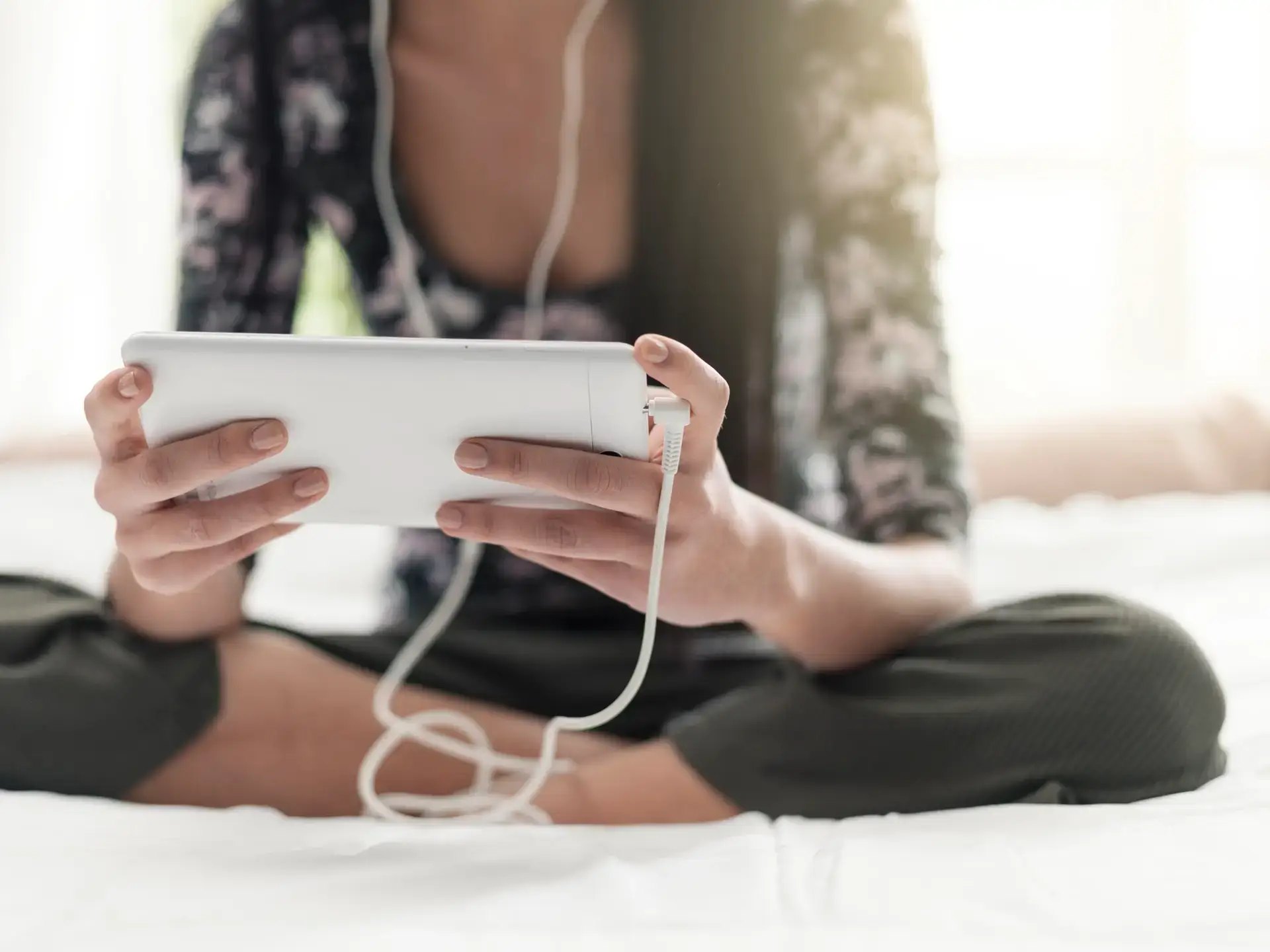 Girl sitting on the bed and watching videos